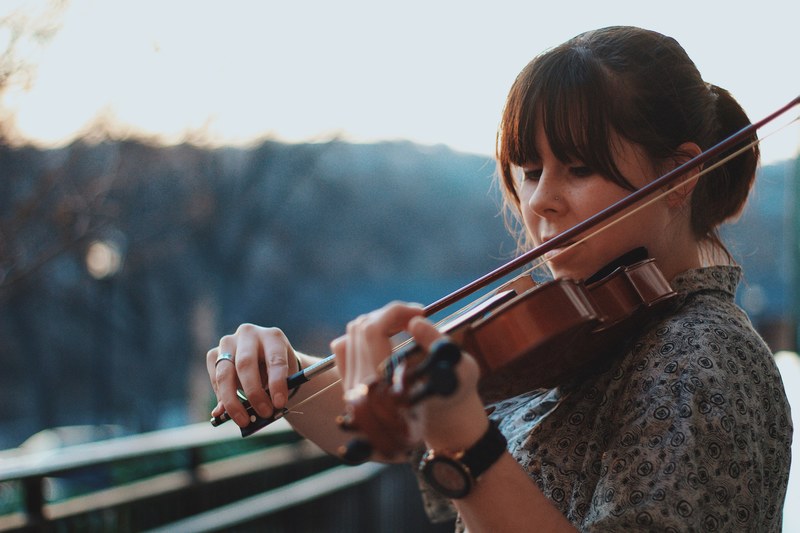 a woman playing a violin outdoors, outdoors violin practice 4k