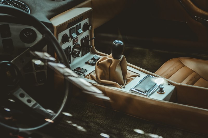 the interior of a vintage car showing the seats gear shift and the steering wheel, _leather car interior 4k