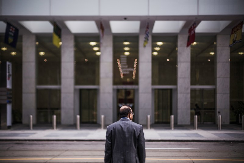 a middle aged man in a suit crossing a street in the financial district, businessman crossing street 4k