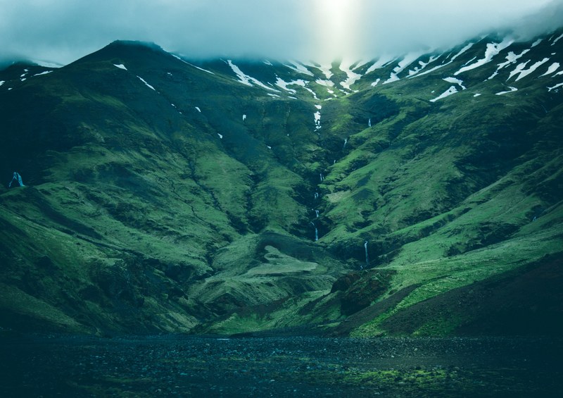 view from the base of a mountain on its steep slope and the mist shrouded peak, steep green slope 4k
