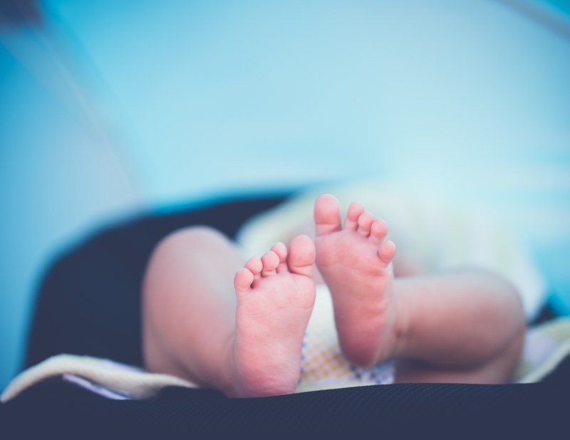 a close up view of a newborn babys feet as the baby lies down, _newborn baby feet 4k