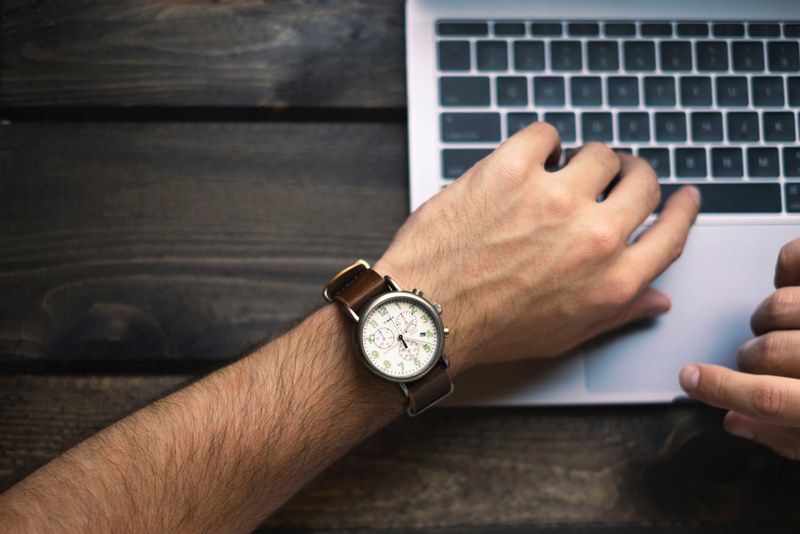 a man wearing a watch typing on a macbook, man in a watch typing 4k