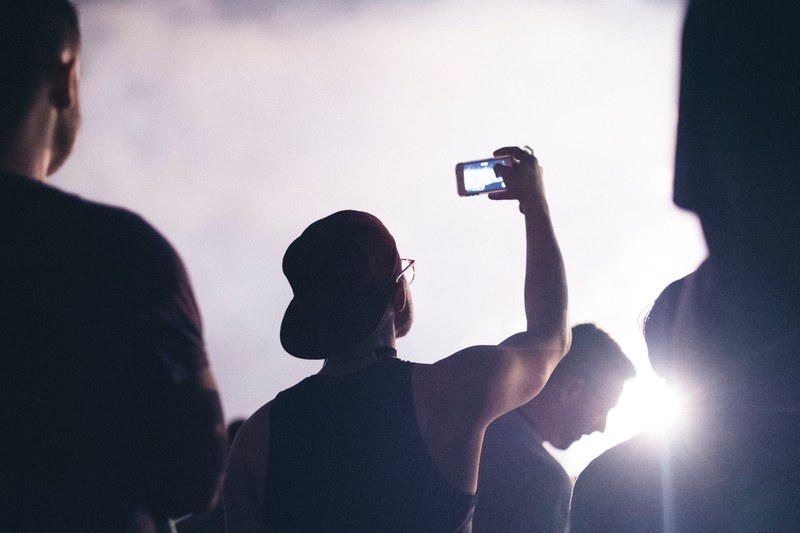 a crowd of people with one person taking a picture of the sky with their phone, _sky picture taking 4k