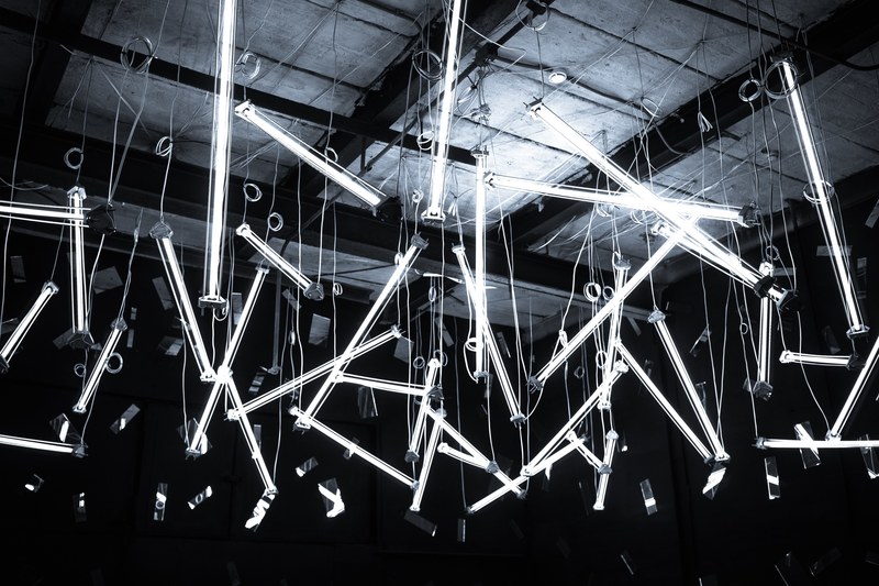 black and white shot of bright glowing striplights hanging at angles in warehouse moscow, hanging striplights moscow 4k