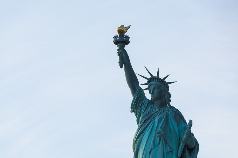 the statue of liberty in new york city with the blue sky behind her, i lift my lamp beside the golden door 4k