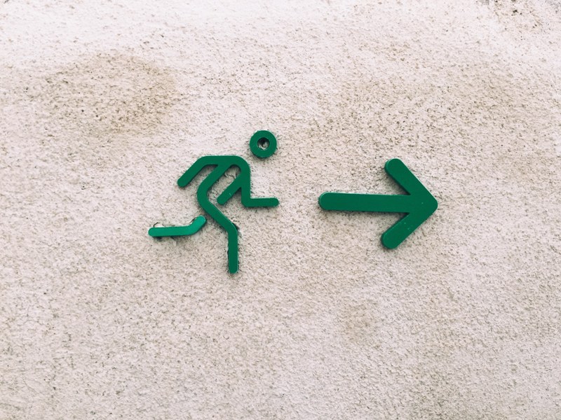 a green sign of a stick figure guy running towards a green arrow, _green stick figure running 4k