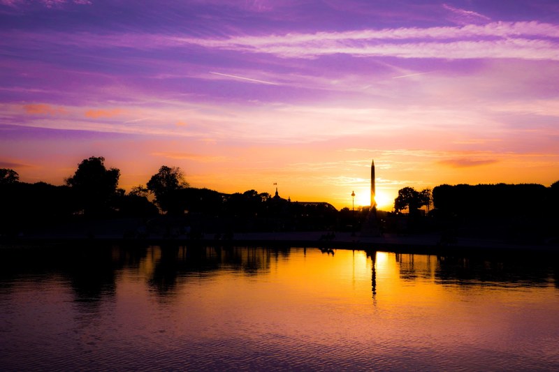 colorful sunset and its reflection over a river with the silhouette of buildings, _sunset reflection over river 4k