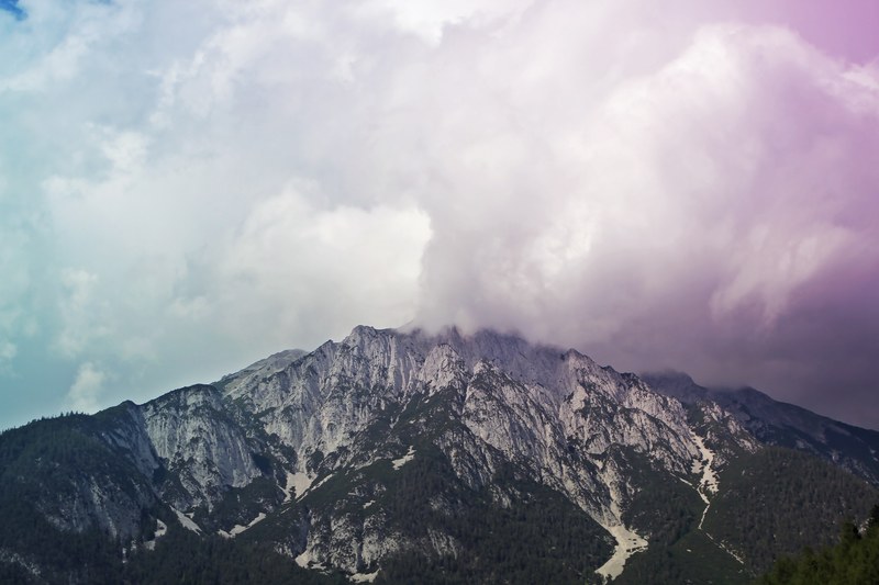 purple hued clouds over a rugged mountain in the swiss alps, purple clouds in the mountains 4k