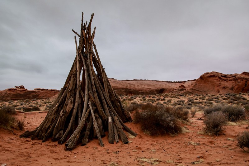 sticks form a rustic teepee in the desert, rustic camping 4k