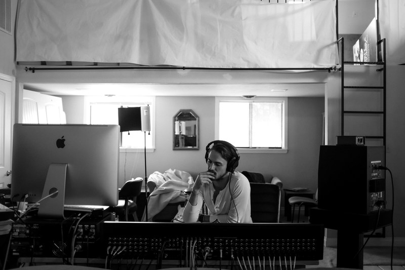 black and white shot of man in apartment studio with headphones mac and monitor las vegas, man in apartment studio 4k