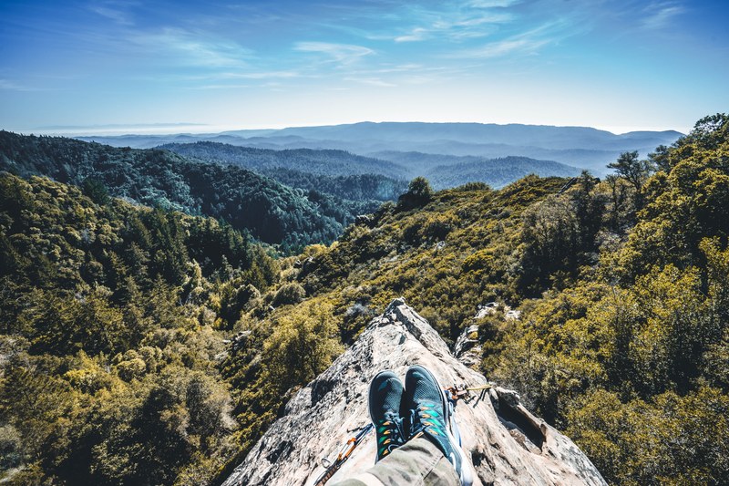 a mountaineers outstretched legs on a rocky ridge, mountaineer on a ridge 4k