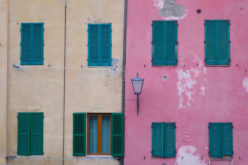 an old building with beige and pink walls with green window shutters in siena, _old building walls siena 4k