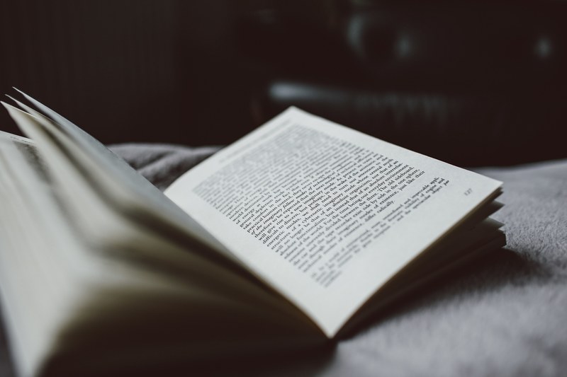 open book on a bed, nighttime reading 4k