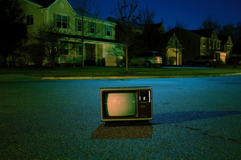 night time shot of retro tv in middle of neighborhood road in suburbs, retro tv on suburban road 4k