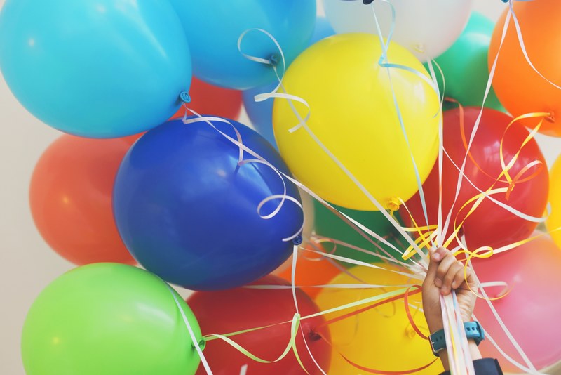 a person holding up a bunch of colorful balloons, _holding colorful balloons 4k