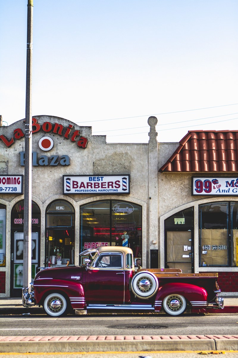 vintage red chevrolet pickup truck parked on pavement in front of barbershop in montebello, red chevrolet barbershop 4k