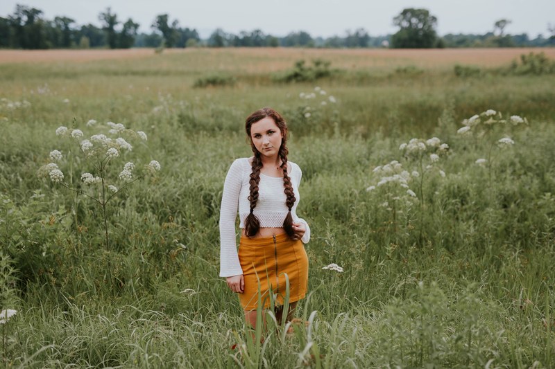 woman with braided hair wearing a in a county chic outfit in a field, country chic outfit 4k