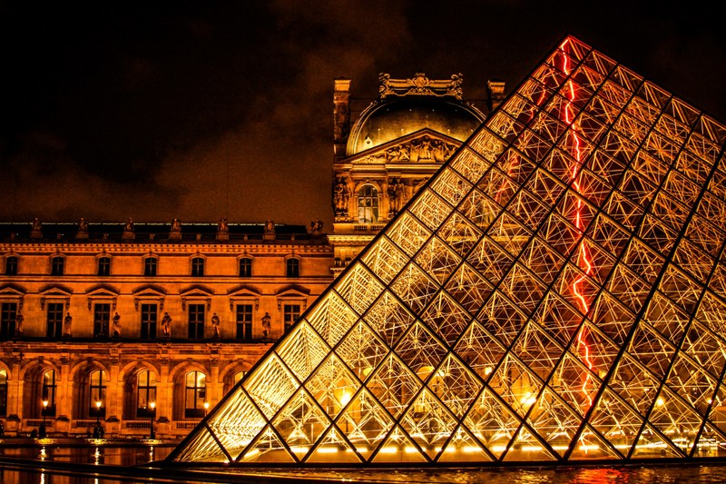 the glowing pyramid in front of the louvre museum at night, bright louvre pyramid 4k