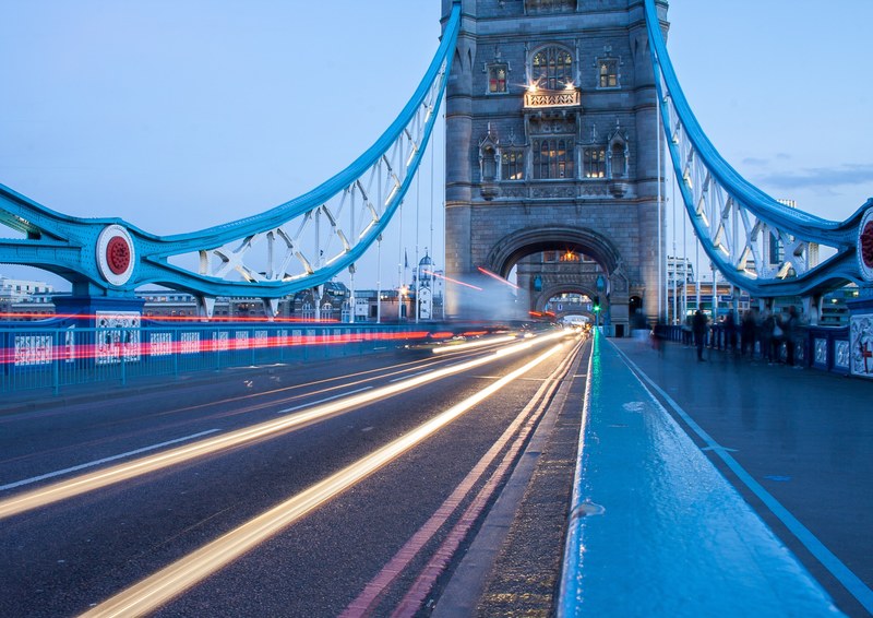 an urban bridge before dusk with headlight and tail light trails from passing traffic, traffic light trails on a bridge 4k