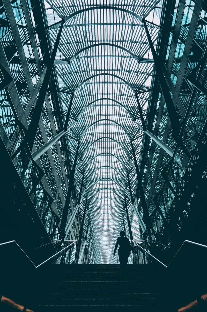a silhouette on stairs in a high ceiling atrium in an office complex in toronto, atrium staircase 4k