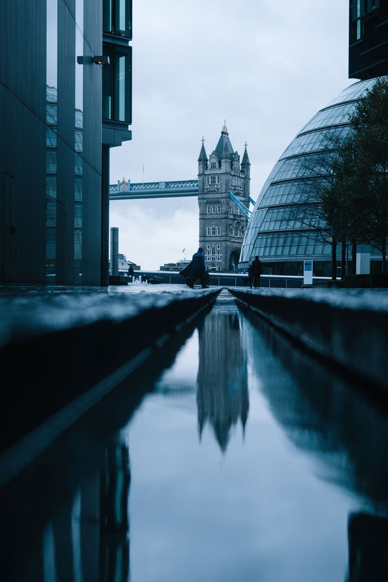 a low shot of a canal in london with a view on the tower bridge, canal and tower bridge 4k