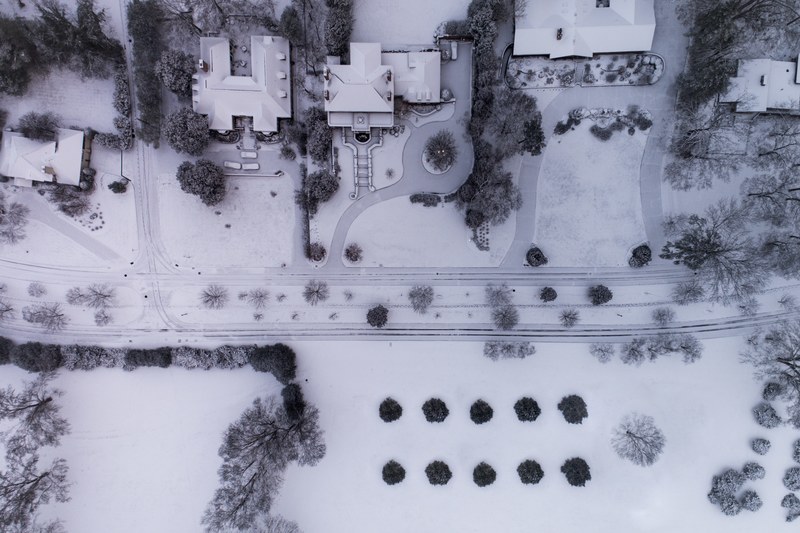 a drone shot of a suburban neighborhood under snow, looking around 4k