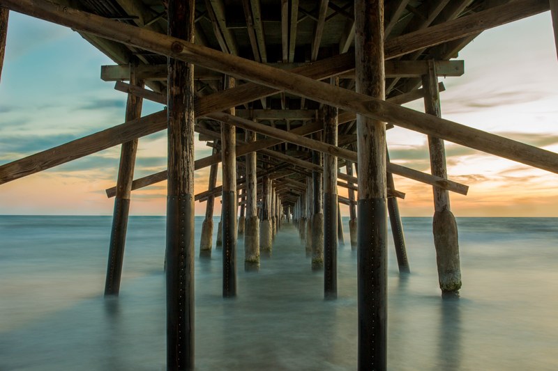 under the pier view of the wooden pier pillars at newport beach, end of the pier 4k