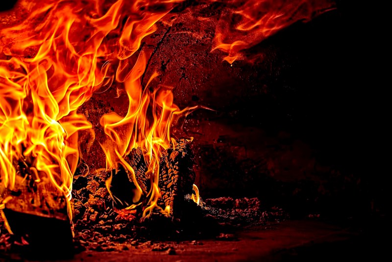 wooden logs in a roaring red and orange fire and coals, the chimney 4k