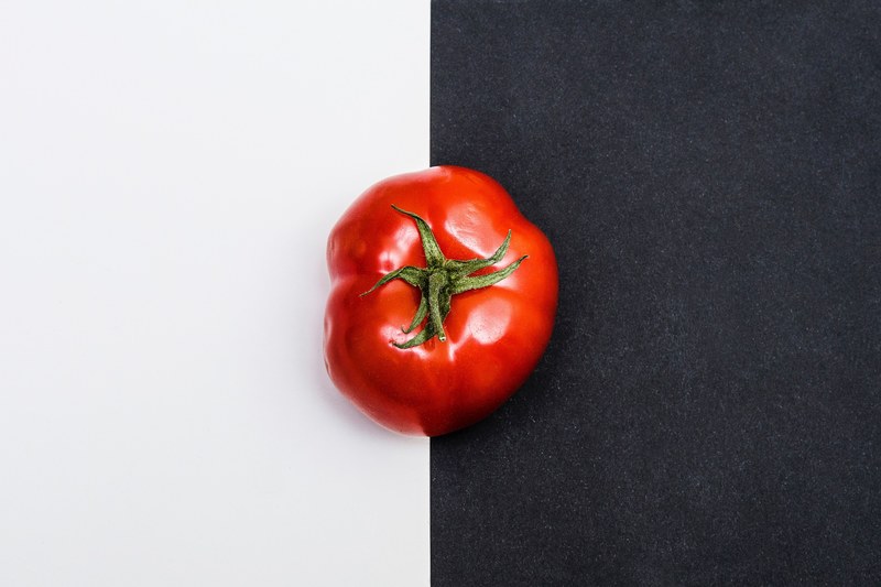 a red tomato with a black and white split background, _half 4k