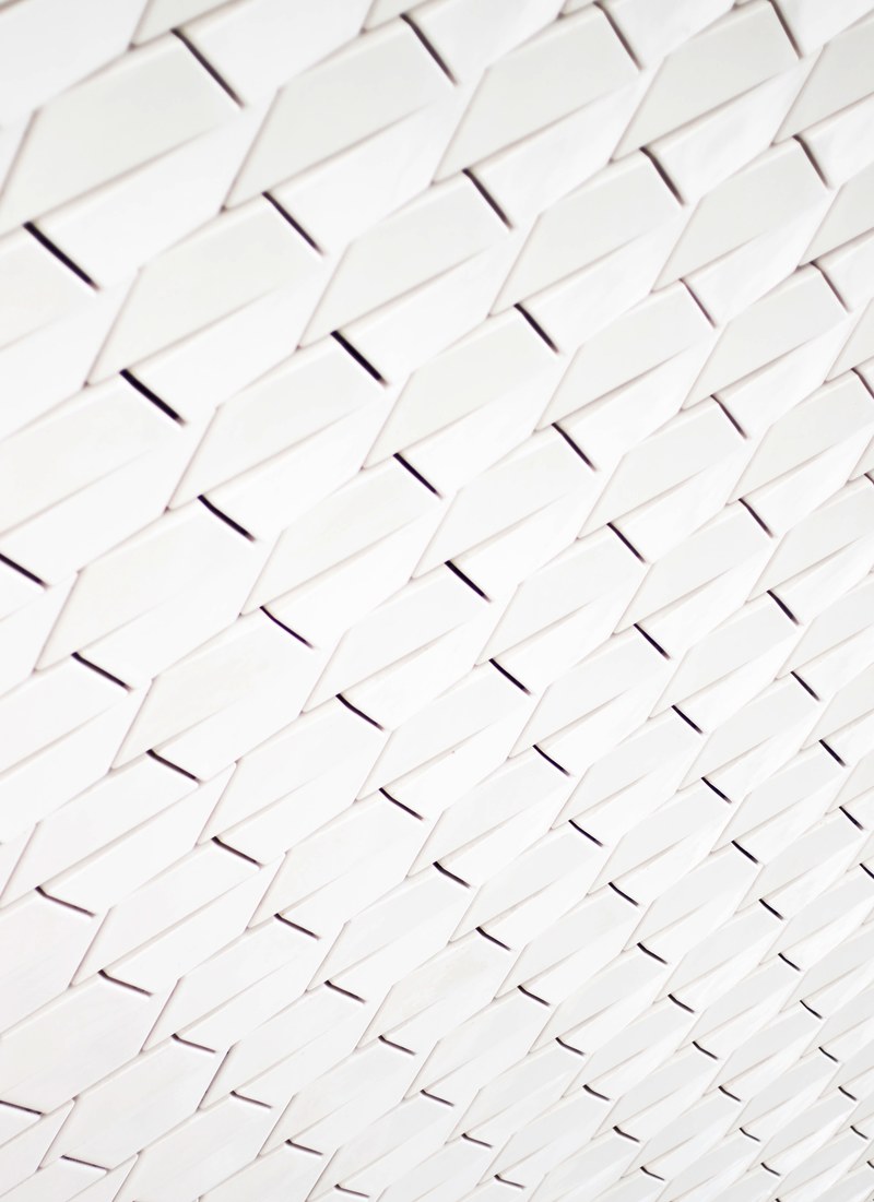 a pattern of white geometric shapes in a facade, maat museum 4k