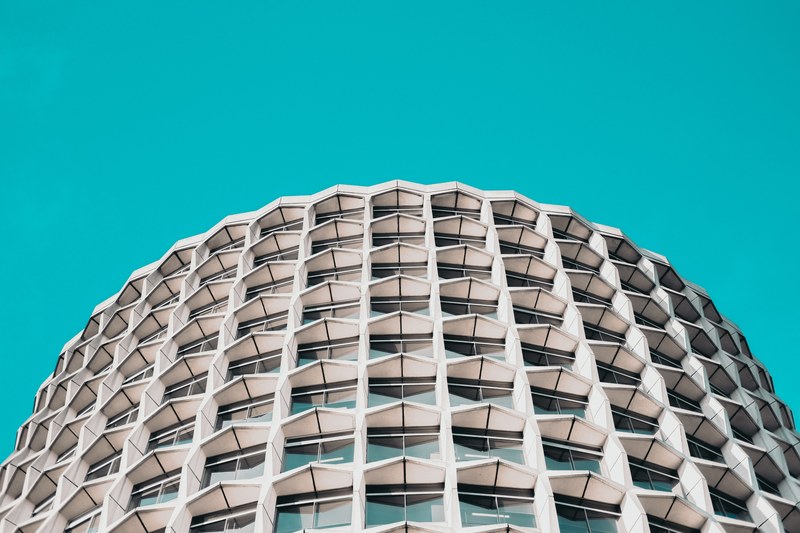 cruciform concrete blocks on the facade of a building under azure sky, modern living 4k