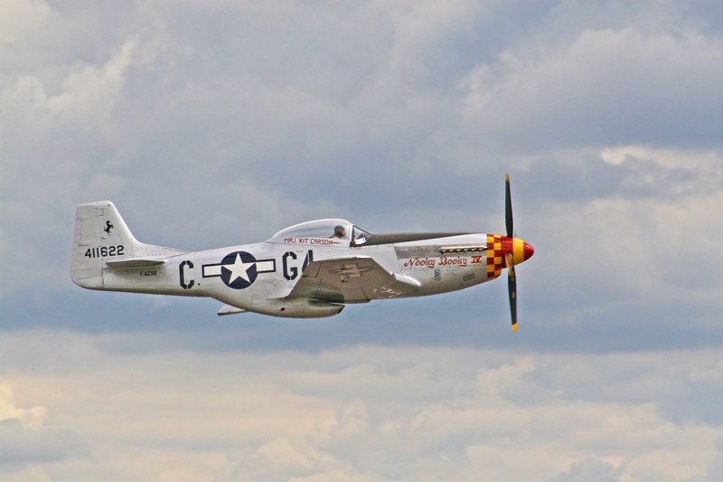 a perfectly captured side shot of a vintage propeller plane in midair, _nooky booky iv on patrol 4k