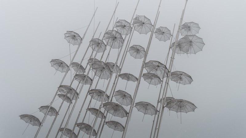 dozen of transparent umbrellas on the flag poles at new beach thessaloniki, snowy day at thessaloniki 4k