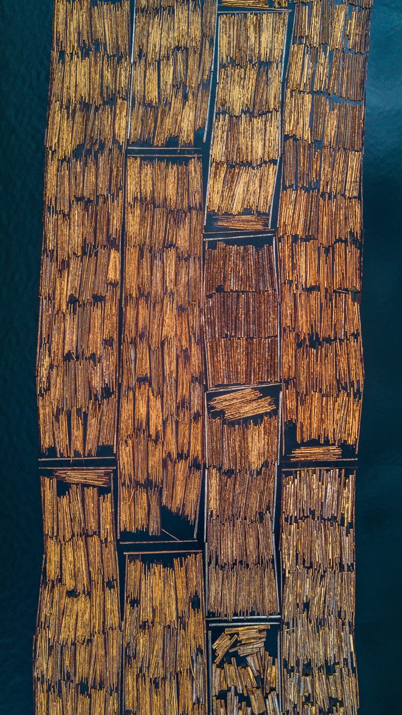 aerial view of bamboo wood transported on rafts on a river, floating industry 4k