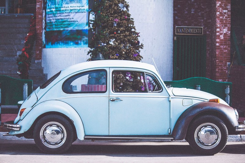retro blue volkswagen beetle parked on street in front of christmas tree and blue poster, parked blue volkswagen beetle 4k