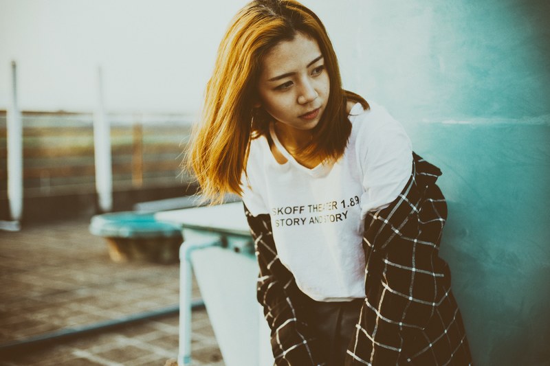 woman in a graphic tee shirt and flannel looking away, urban street outfit 4k