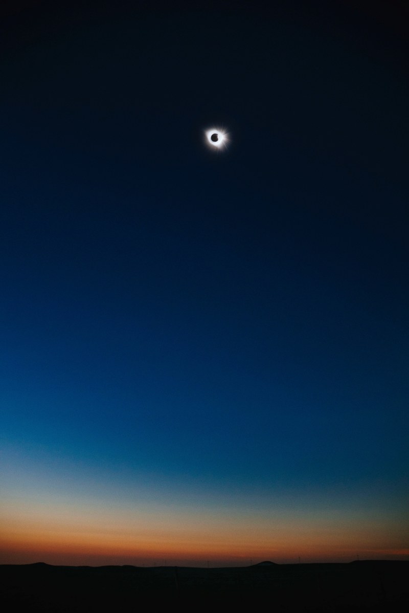 solar eclipse glows against a colorful blue sky, total eclipse of my heart 4k
