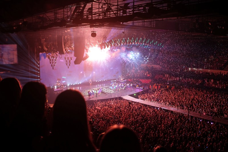 a high shot of a full concert hall with people lined up on the stage under bright lights, full venue during a performance 4k