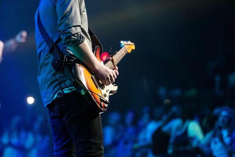 low shot of a musician playing guitar during a sold out concert, guitarist at a show 4k