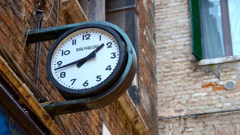 round clock with black border reading 143 attached to the side of a brick building, round clock brick building 4k