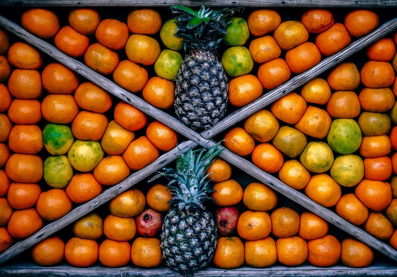 top view of a fruit bin featuring pineapples and other fruits, _fruit presentation 4k