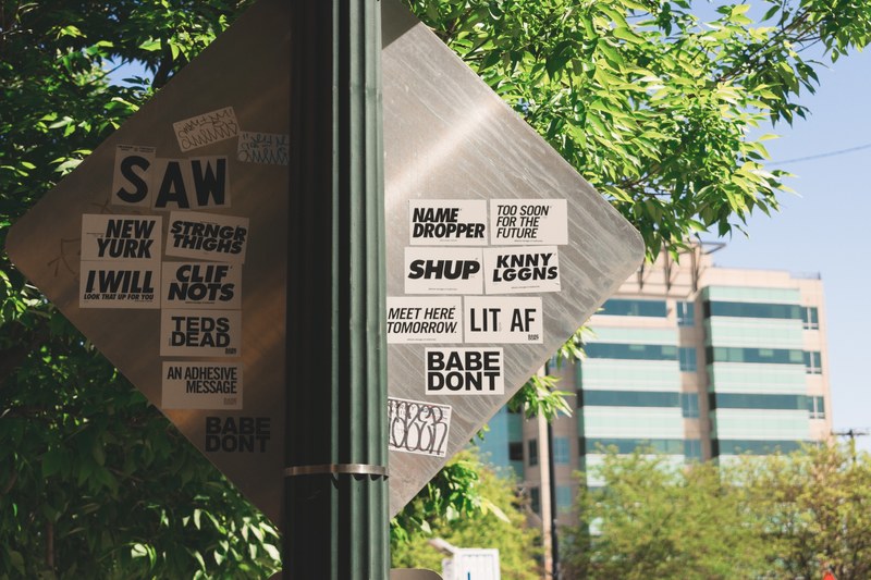 various stickers with different messages are stuck on the back of a road sign in boise, _recognize the signs 4k