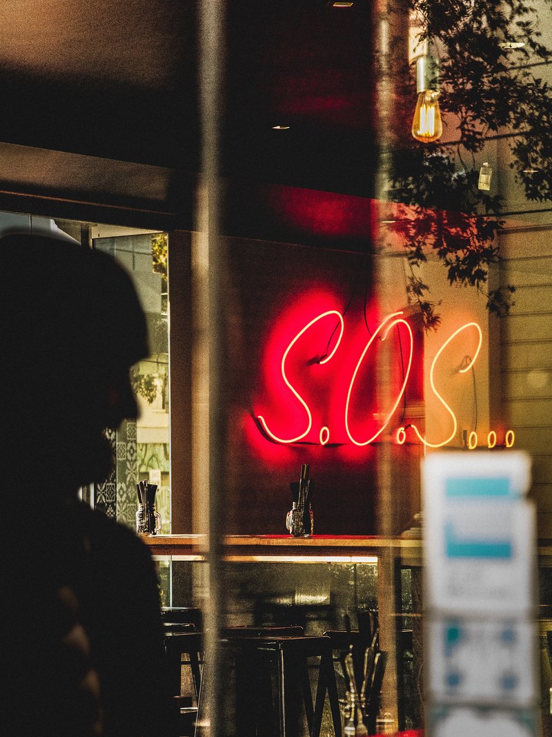a neon sign in a bar spells out so_s, sos neon sign 4k