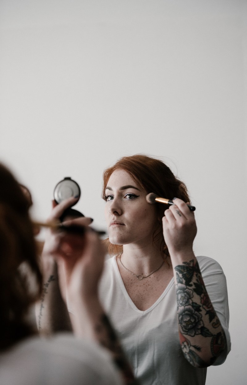 woman applying blusher highlighter make up 4k