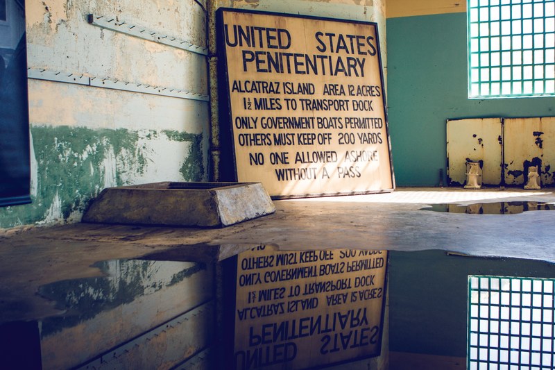 puddle in an abandoned jail cell reflects old yellow sign for the united states penitentiary, _abandoned jail cell 4k