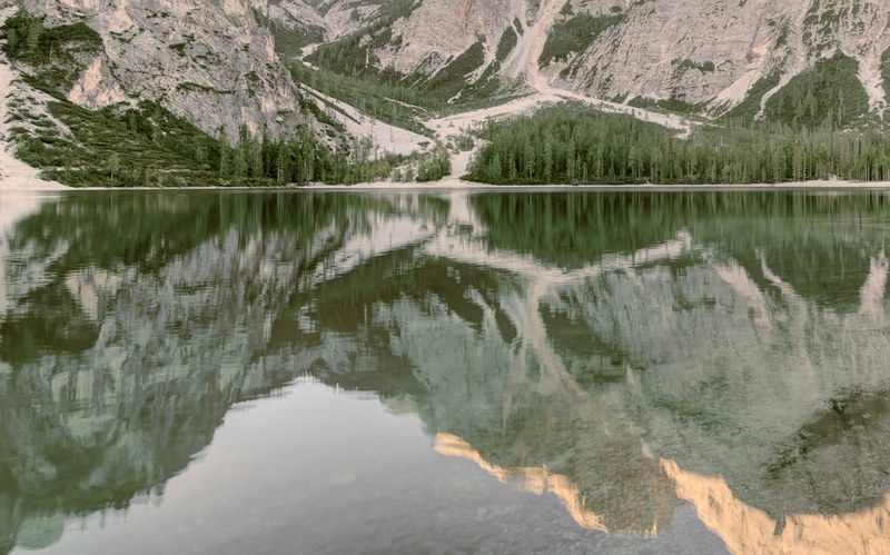 granite mountains reflected in the still surface of lake pragser wildsee, summer is in the air 4k