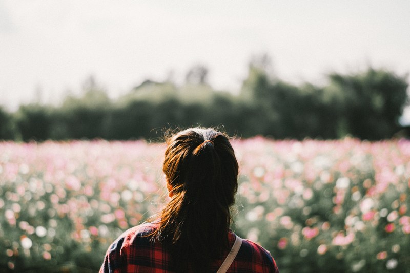 a shot from behind a womans heat as she stares out at the gardens at jim thompson farm, jim thompson farm thailand 4k