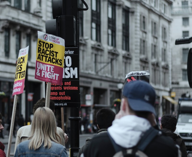 people with protest signs in oxford street london, around anti racism protesters in london 4k
