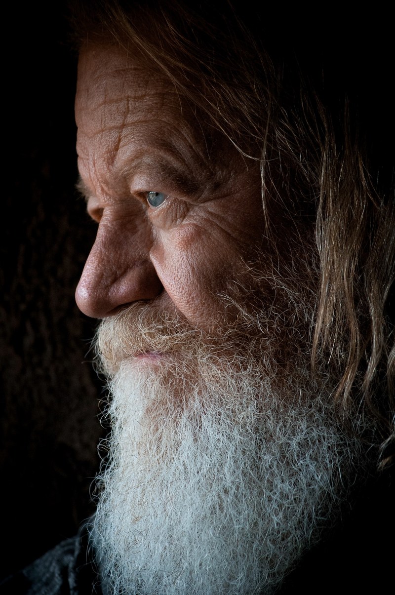 a dark portrait of an elderly man with a gray beard and wrinkled face, _old man with gray beard 4k