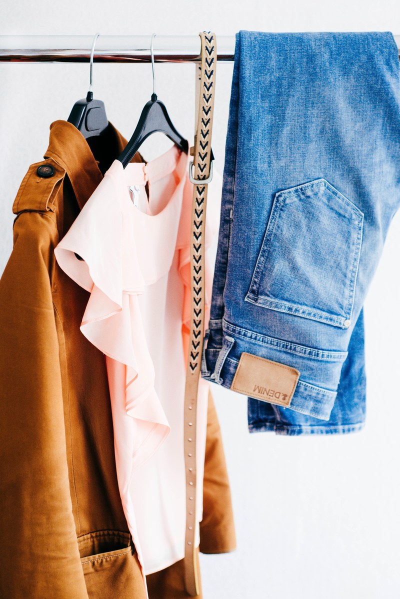womens shirts jeans and belt hanging on a clothing rack, wardrobe 4k